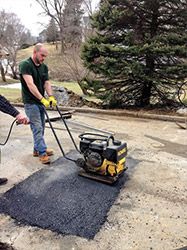 Picture of a team member repairing the asphalt