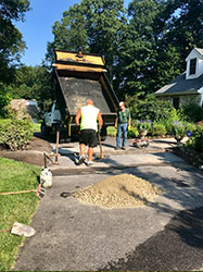 Picture of a truck and workers making asphalt repairs